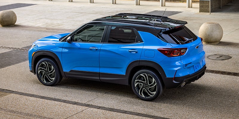 A blue 2024 Chevy Trailblazer driving down a road.