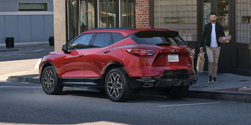 A photo of a red 2025 Chevy Blazer parked on a city street.